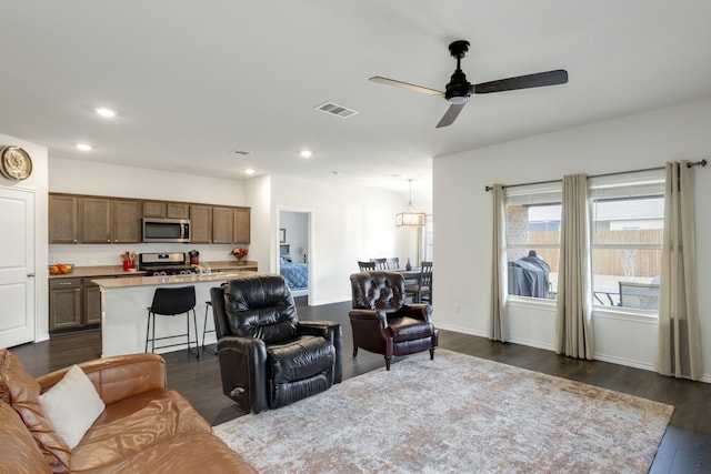 living room with dark hardwood / wood-style floors and ceiling fan