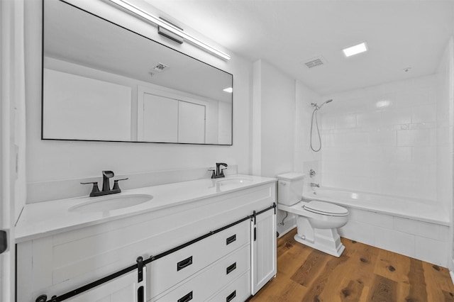 full bathroom with hardwood / wood-style floors, vanity, toilet, and washtub / shower combination