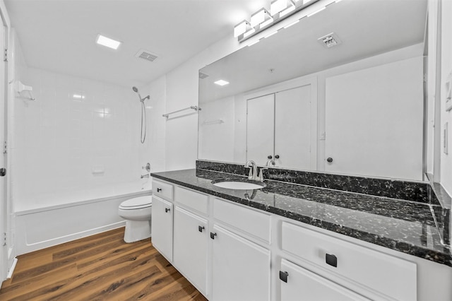 full bathroom with hardwood / wood-style floors, vanity, toilet, and tiled shower / bath combo