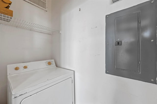 clothes washing area with electric panel and washer / dryer