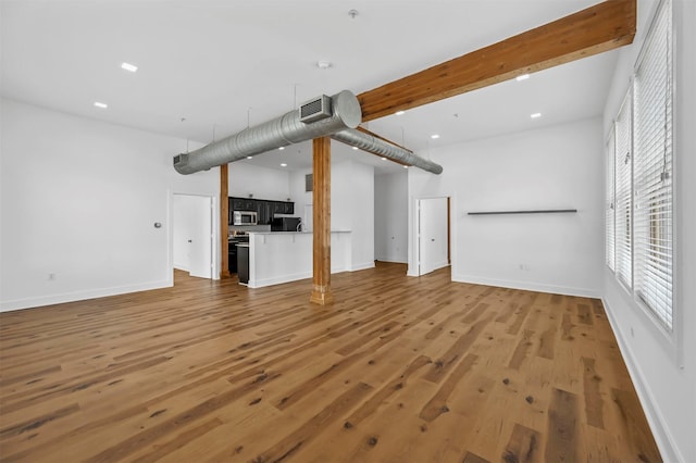 unfurnished living room with hardwood / wood-style flooring and beam ceiling