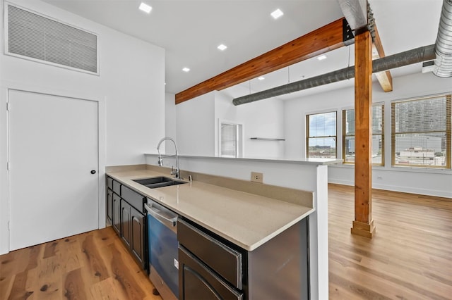 kitchen featuring kitchen peninsula, stainless steel dishwasher, sink, beamed ceiling, and light hardwood / wood-style floors