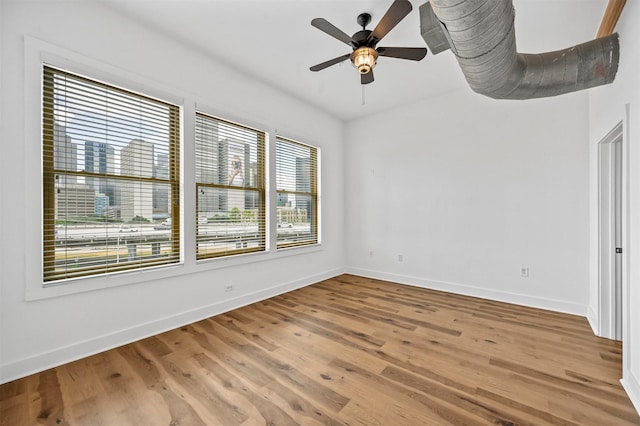 unfurnished room with hardwood / wood-style floors, plenty of natural light, and ceiling fan