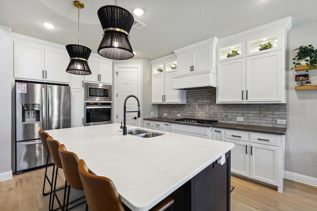 kitchen featuring decorative light fixtures, sink, white cabinets, and appliances with stainless steel finishes