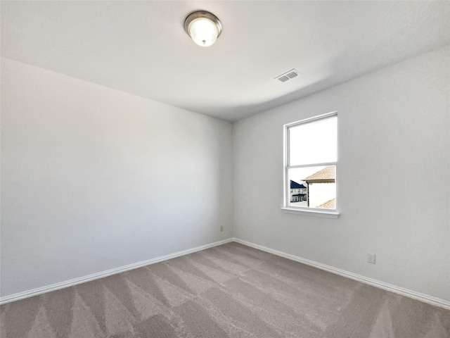 spare room featuring light colored carpet