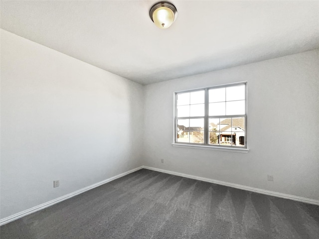 unfurnished room featuring dark colored carpet