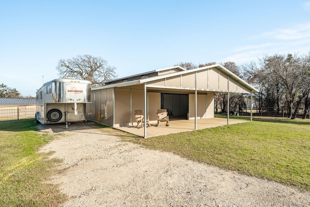 rear view of house featuring a lawn and a carport