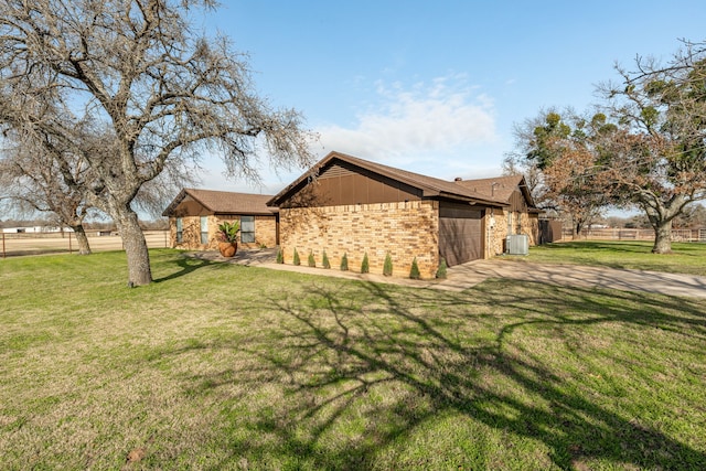 ranch-style home with a garage, central AC unit, and a front lawn