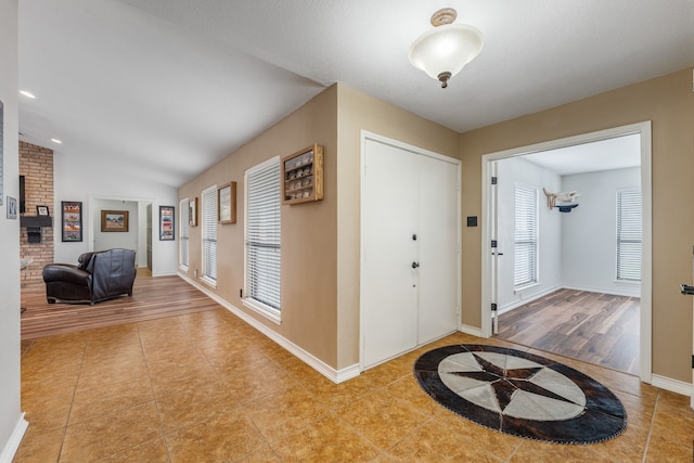 foyer featuring vaulted ceiling and light tile patterned floors