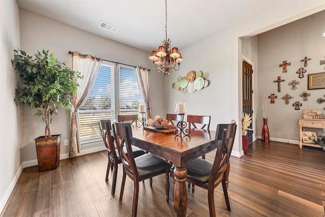 dining space featuring dark wood-type flooring and an inviting chandelier