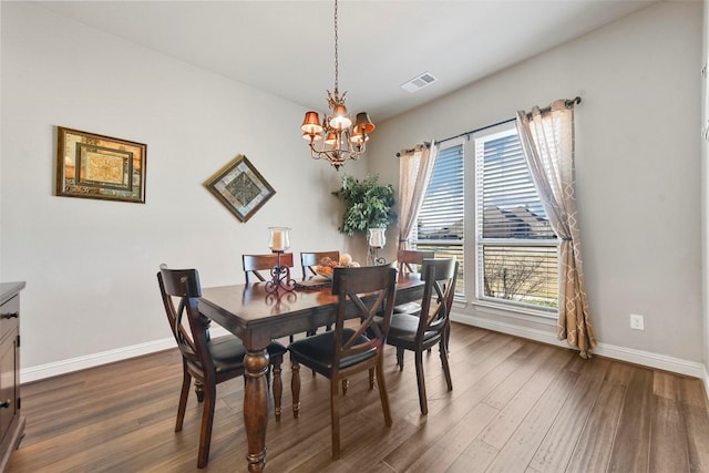 dining area featuring dark hardwood / wood-style floors, an inviting chandelier, and plenty of natural light