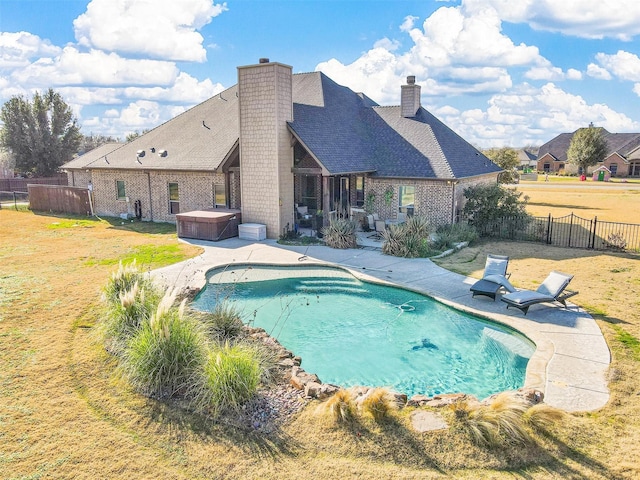 view of pool featuring a lawn, a patio, and a hot tub