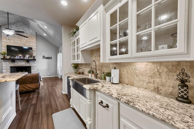 kitchen featuring backsplash, ceiling fan, sink, white cabinets, and lofted ceiling