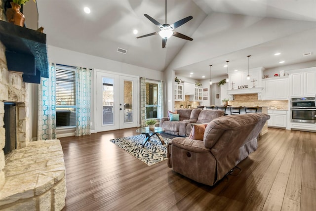 living room with ceiling fan, french doors, high vaulted ceiling, and hardwood / wood-style flooring