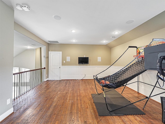 workout room with hardwood / wood-style floors and vaulted ceiling