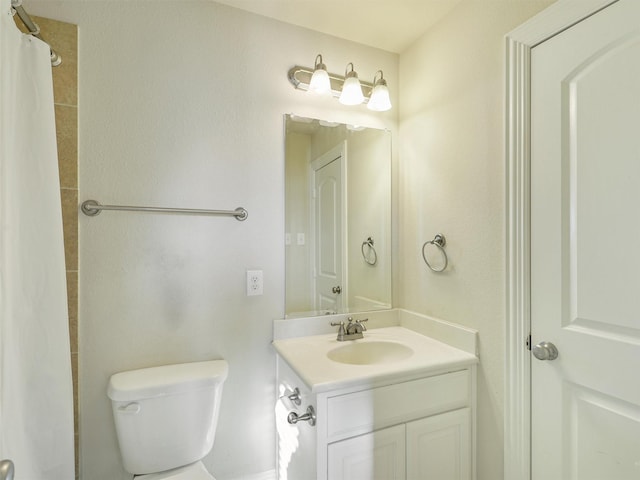 bathroom featuring toilet, walk in shower, and vanity