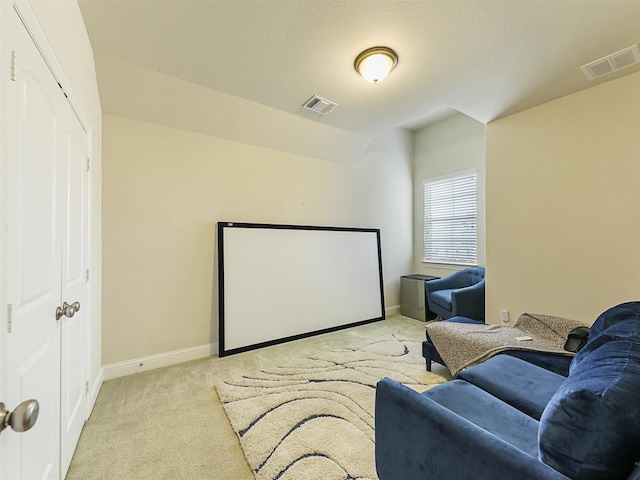 cinema with light carpet and lofted ceiling