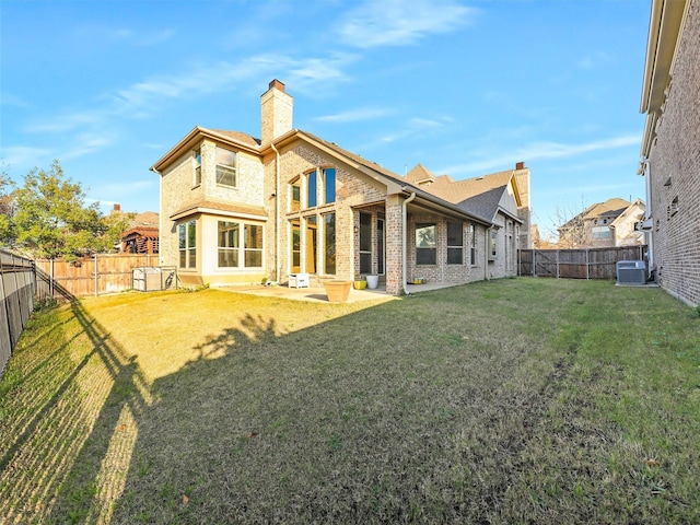 rear view of house with central AC unit and a yard