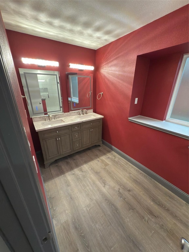 bathroom with hardwood / wood-style floors, a textured ceiling, and vanity