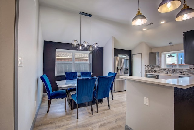 dining room featuring lofted ceiling and light wood-type flooring