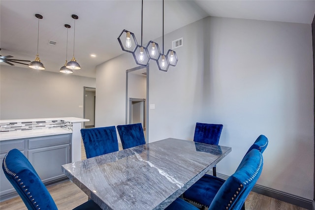 dining area featuring vaulted ceiling, light hardwood / wood-style floors, and ceiling fan