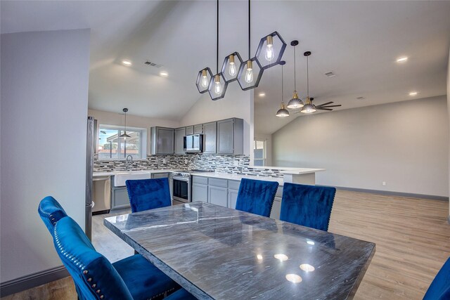 unfurnished living room featuring light hardwood / wood-style floors, vaulted ceiling, ceiling fan, and a fireplace