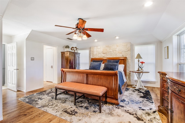 bedroom featuring ceiling fan, lofted ceiling, ornamental molding, and light hardwood / wood-style flooring