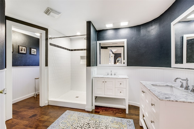 bathroom featuring hardwood / wood-style floors, vanity, and tiled shower