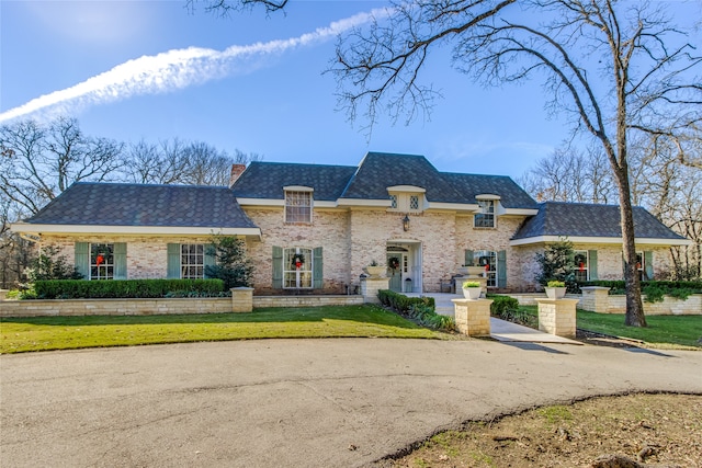 french provincial home with a front lawn