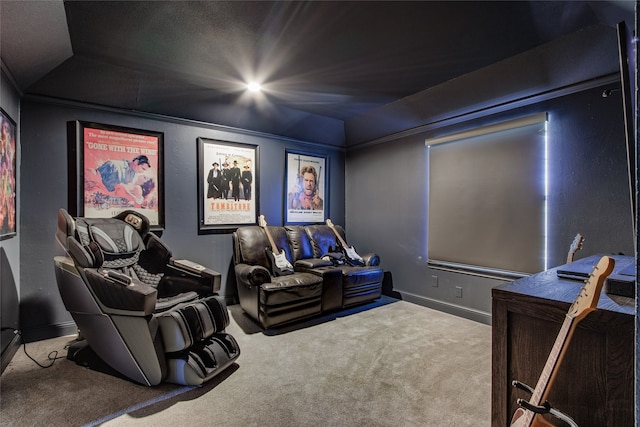 home theater featuring carpet flooring, ornamental molding, and vaulted ceiling