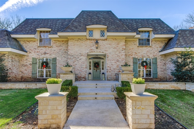 french country inspired facade with a front lawn