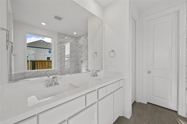 bathroom with vanity and a tile shower