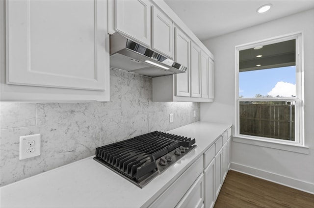 kitchen featuring backsplash, stainless steel gas stovetop, dark hardwood / wood-style floors, and white cabinets