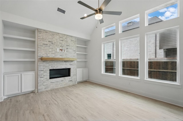 1829 Dolce Ln, Mclendon Chisholm, TX 75032 - unfurnished living room with a glass covered fireplace, built in features, visible vents, ceiling fan, and wood finished floors