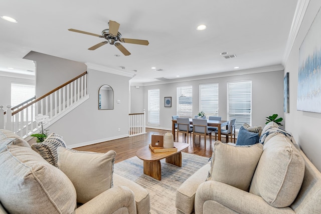 living room with ceiling fan, light wood-type flooring, and crown molding