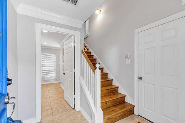 stairway with tile patterned floors and crown molding