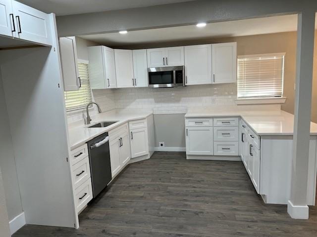 kitchen with sink, dark hardwood / wood-style floors, tasteful backsplash, white cabinetry, and stainless steel appliances