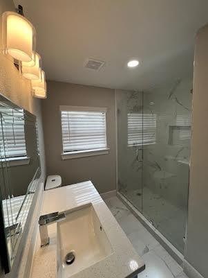 bathroom with vanity, toilet, and an enclosed shower