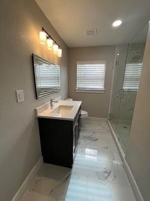 bathroom with vanity, a shower with shower door, and toilet