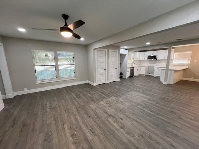 unfurnished living room featuring dark hardwood / wood-style floors and ceiling fan