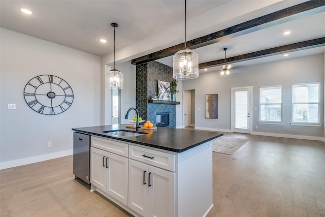 kitchen featuring white cabinets, pendant lighting, dishwasher, and sink