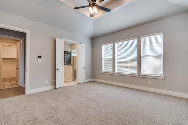 unfurnished bedroom featuring vaulted ceiling, light colored carpet, ceiling fan, and ensuite bath