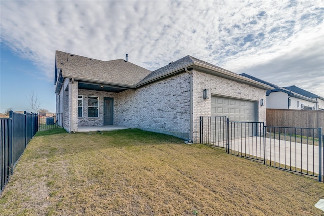 rear view of property featuring a yard and a garage