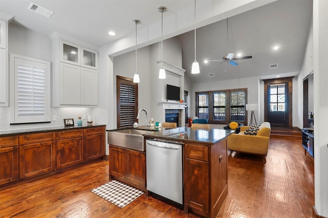 kitchen featuring decorative backsplash, sink, pendant lighting, a center island with sink, and dishwasher