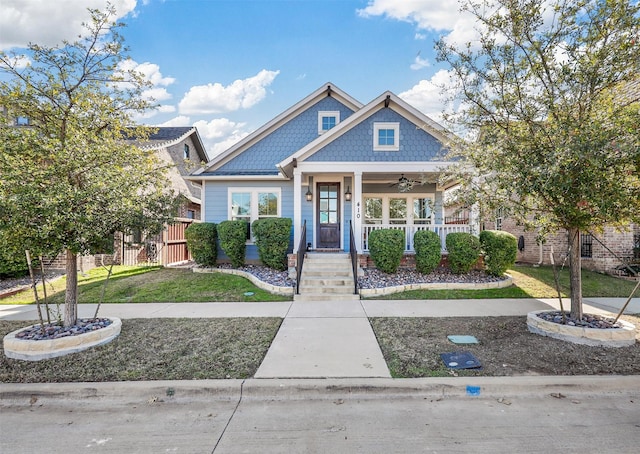 view of front of house with a front yard, ceiling fan, and covered porch