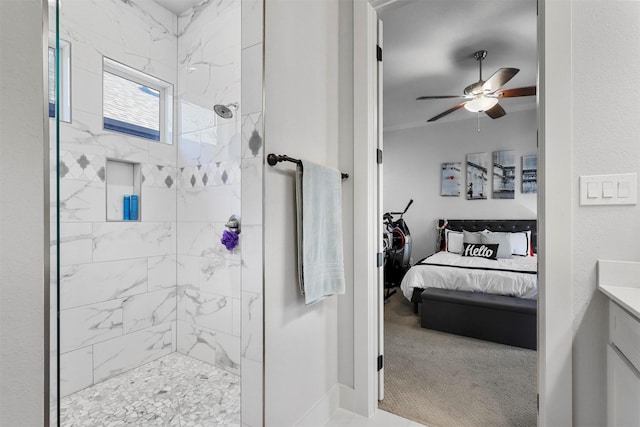 bathroom with vanity, ceiling fan, and a tile shower