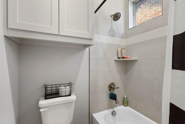 bathroom with tiled shower / bath combo and toilet