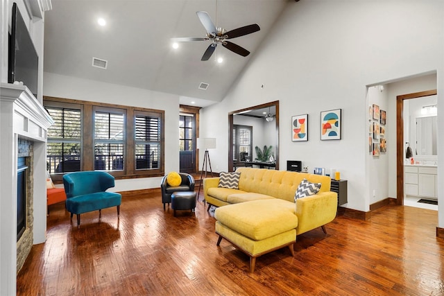 living room featuring hardwood / wood-style flooring, high vaulted ceiling, and ceiling fan