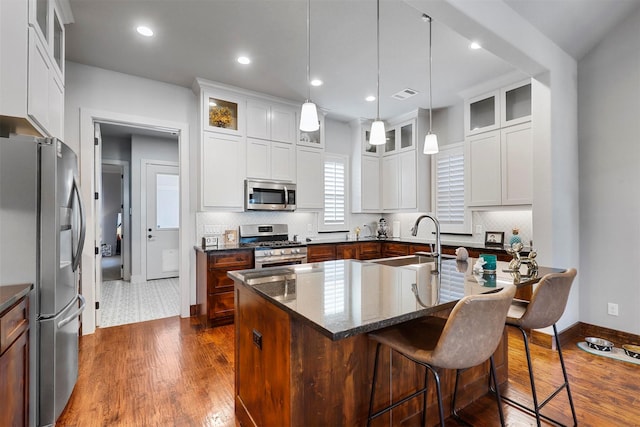 kitchen featuring white cabinets, sink, a kitchen island with sink, and stainless steel appliances