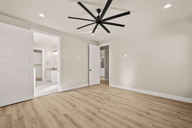 unfurnished bedroom with ensuite bathroom, ceiling fan, and light wood-type flooring